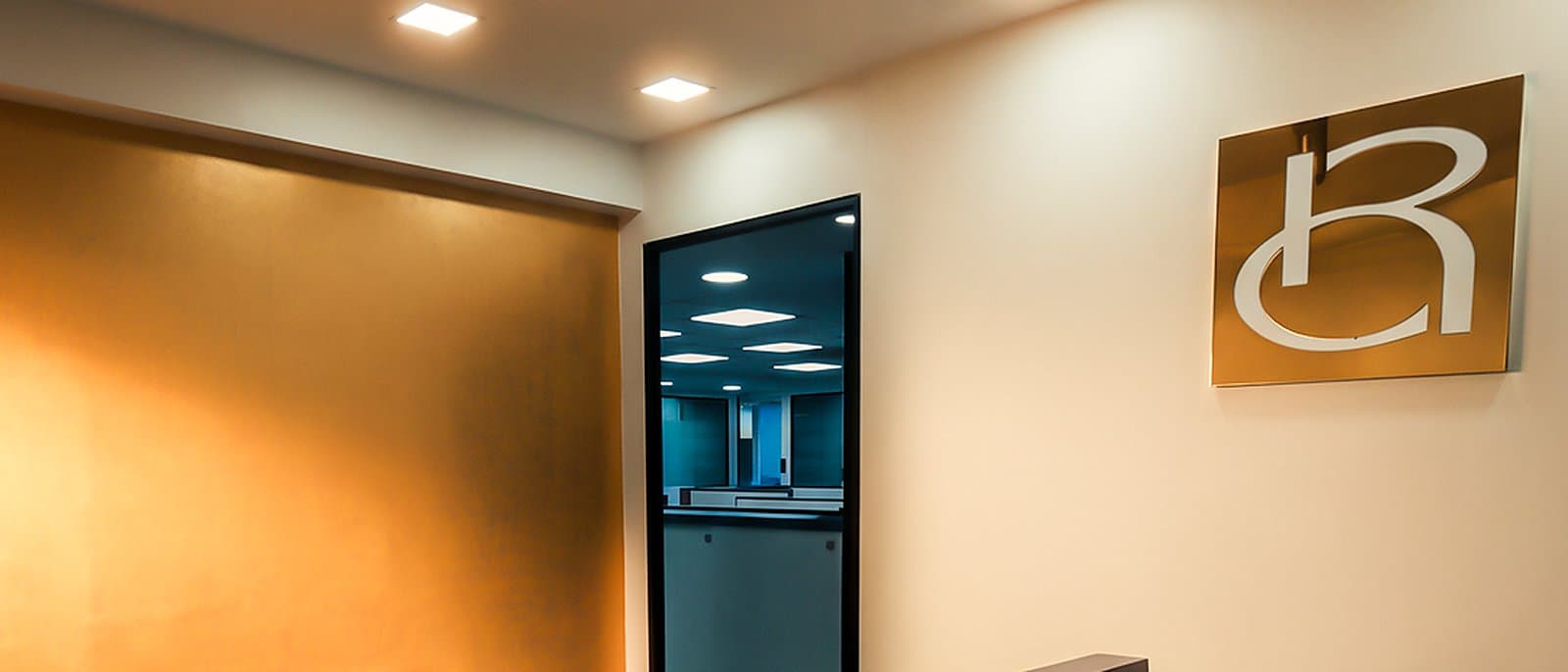 The reception of the Rathod Jewellery office in Mumbai, with the Rathod monogram on the wall