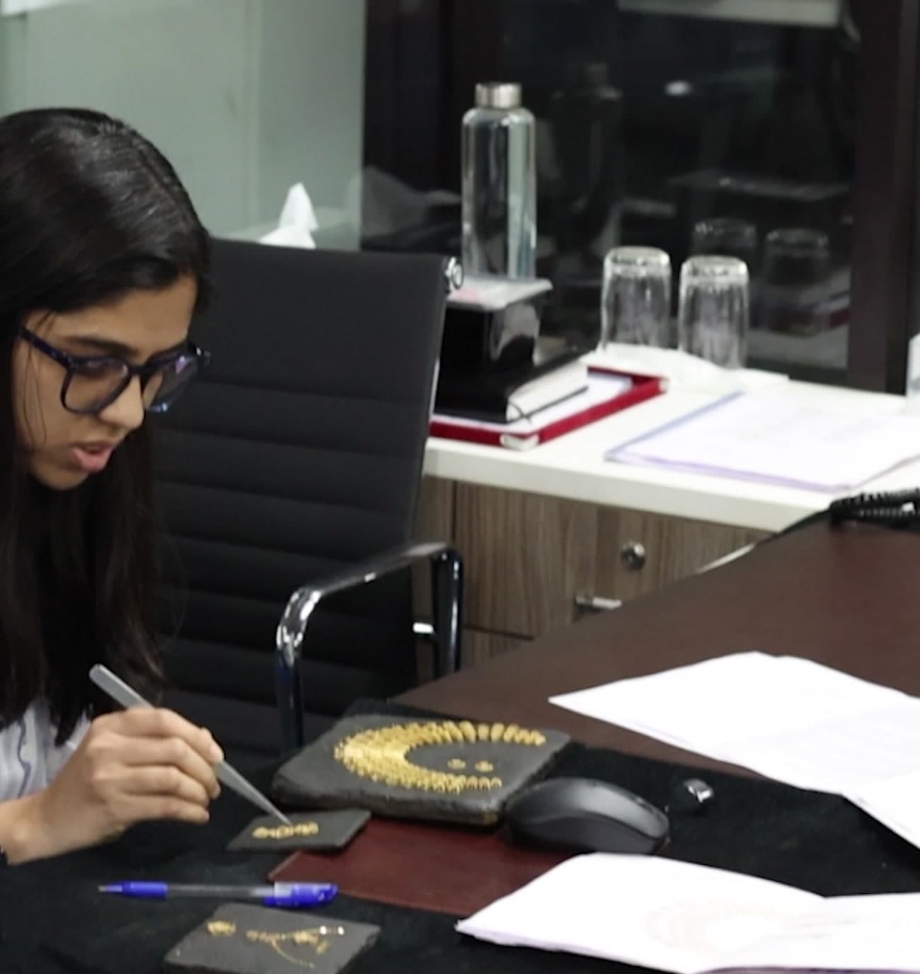 A designer sketching jewellery at her desk in the Kolhapur facility